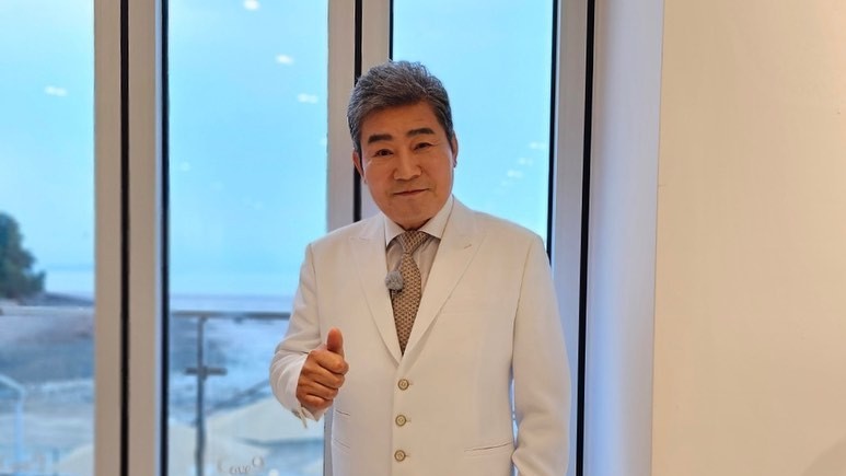진성이 파란색 체크 재킷을 입고 인터뷰하며 웃는 모습