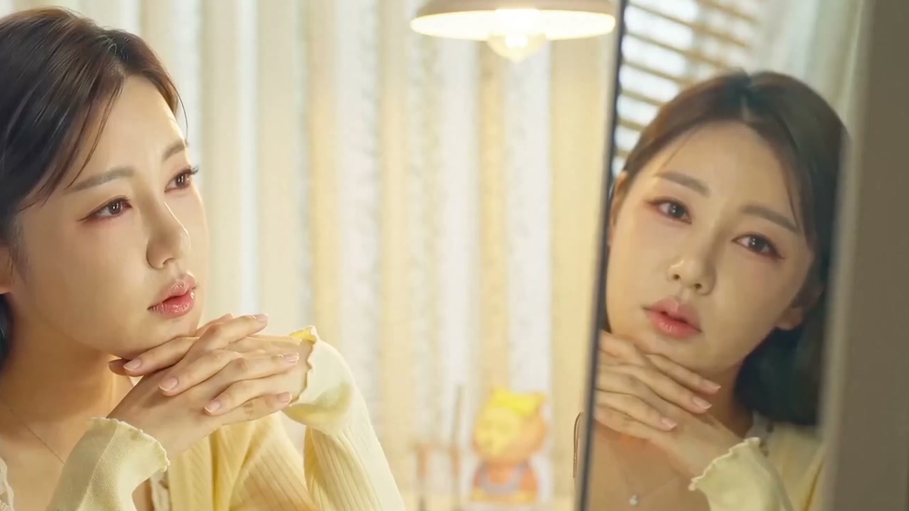 송가인이 노란 카디건 차림으로 거울을 보며 턱을 괴고 있는 모습, 송가인 공식 유튜브 뮤직비디오 장면