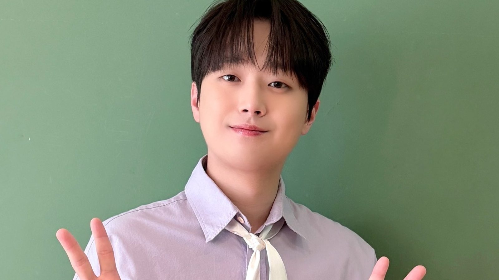 이찬원이 연두색 배경 앞에서 브이 자를 그리며 웃고 있는 얼굴 클로즈업