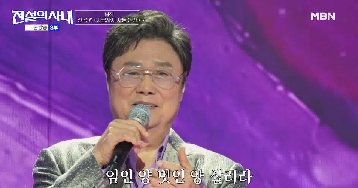 보랏빛 무대에서 마이크를 들고 신곡을 부르는 남진