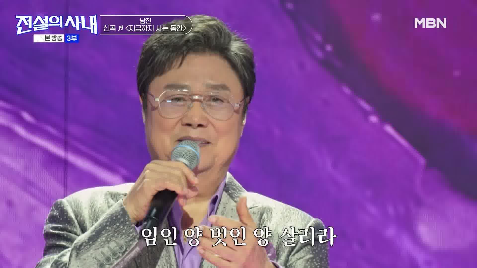 보랏빛 무대에서 마이크를 들고 신곡을 부르는 남진
