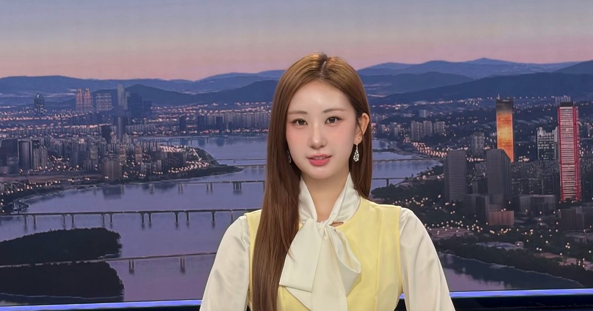 노란 조끼와 흰 리본 블라우스 차림으로 한강 야경 배경 앞에 선 전유진