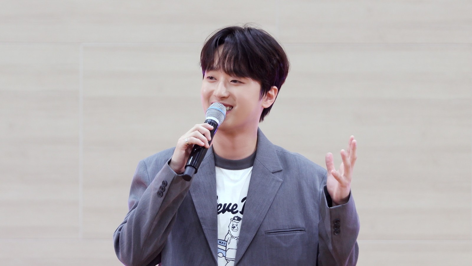이찬원이 마이크를 들고 환하게 웃으며 이야기하는 모습