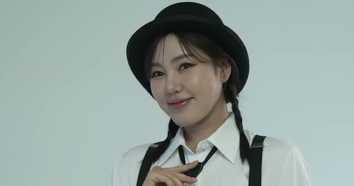 검정 중절모와 흰 셔츠, 멜빵 차림으로 카메라를 보며 미소 짓는 송가인