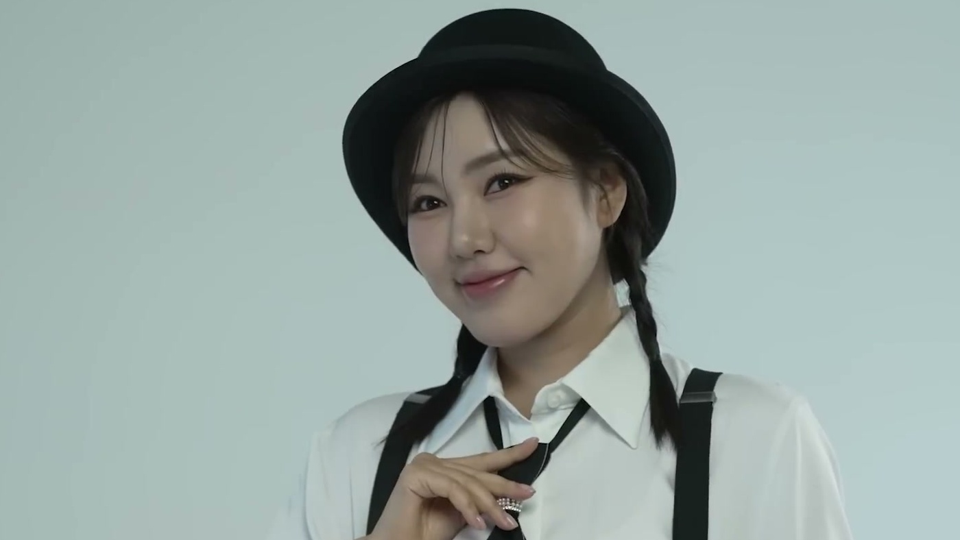 검정 중절모와 흰 셔츠, 멜빵 차림으로 카메라를 보며 미소 짓는 송가인