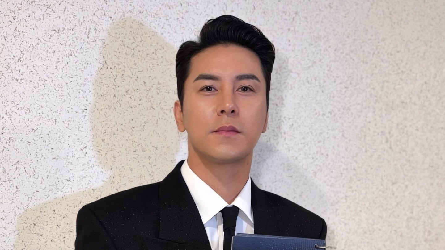 검은 정장에 넥타이를 매고 정면을 바라보는 장민호