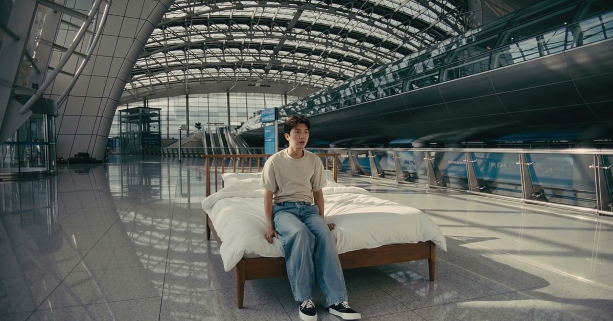 공항 로비에 놓인 침대에 앉아 있는 임영웅