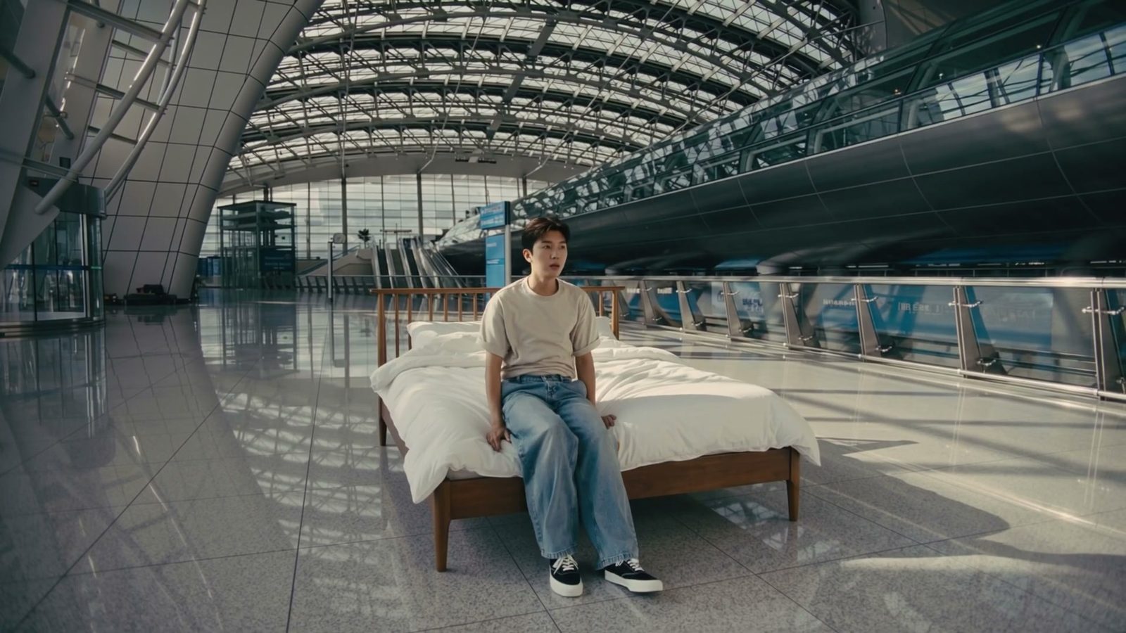 공항 로비에 놓인 침대에 앉아 있는 임영웅