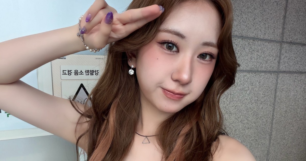 갈색 웨이브 머리의 전유진이 손으로 이마 옆에 브이 모양 경례를 하며 웃는 셀카