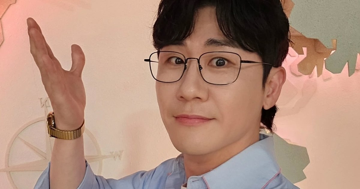 안경을 쓰고 정면을 바라보며 손을 들어 보이는 영탁